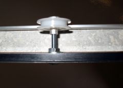 Closeup of plexiglas panel roller assembly